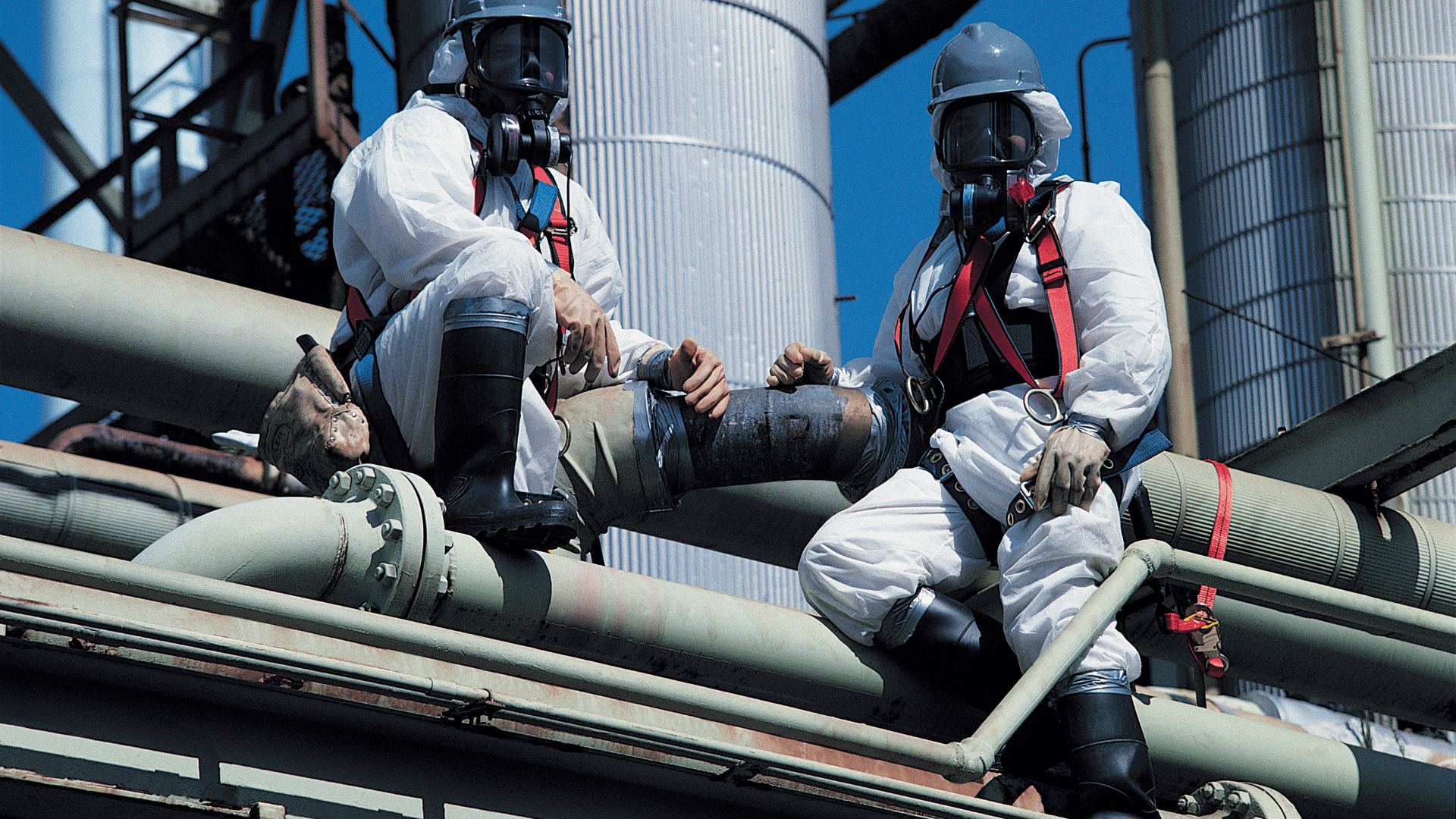 Abatement workers in protective suits on an industrial site
